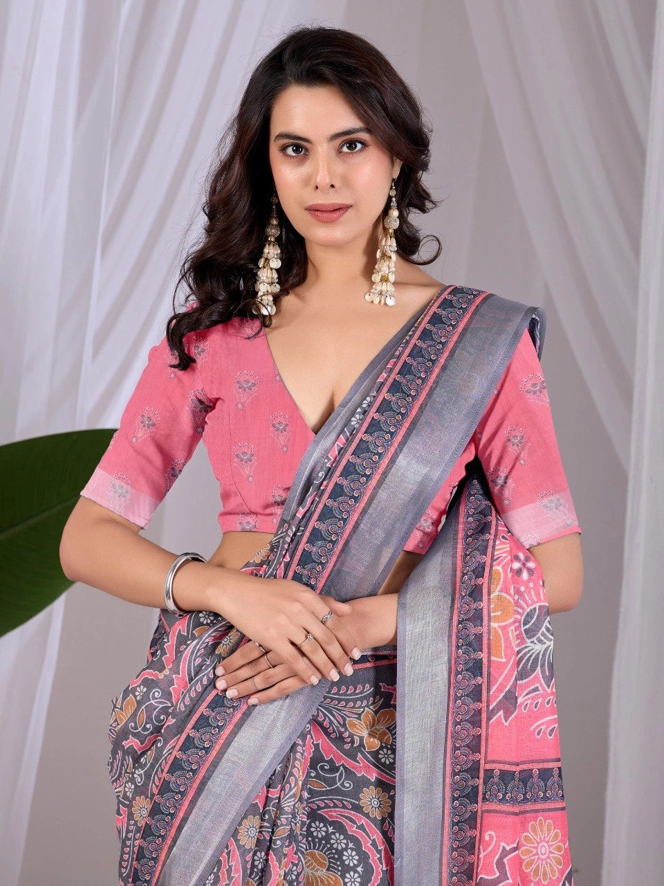 Woman wearing a pink and gray saree with a white background
