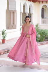 Woman in a pink traditional outfit standing in front of an architectural building.