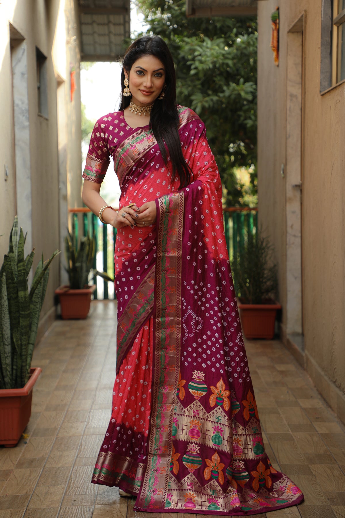 Woman wearing a vibrant saree with a patterned design in an indoor setting.