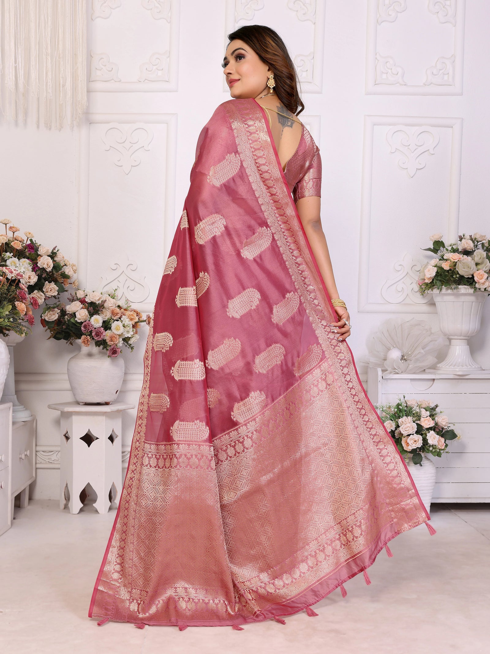 Woman wearing a pink saree with a white background