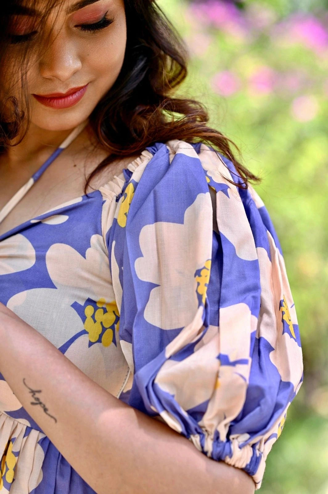 Woman wearing a floral dress with a blurred natural background