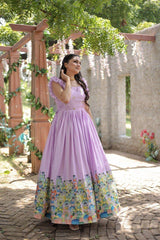 Woman in a lavender dress with floral pattern standing outdoors.