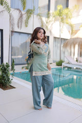 Woman in traditional outfit by a poolside with modern building in background