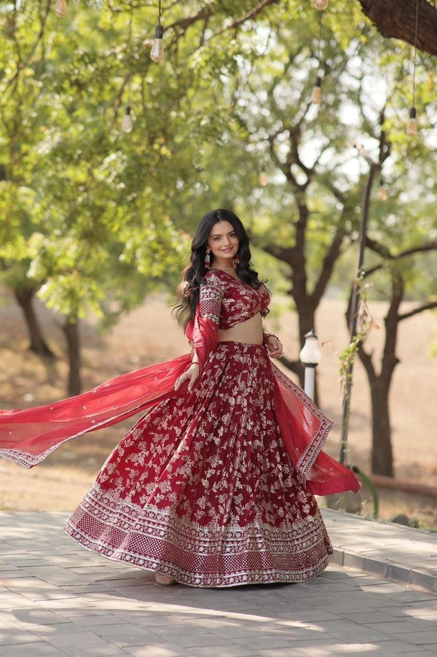 Woman in a red and white traditional outfit standing outdoors with trees in the background