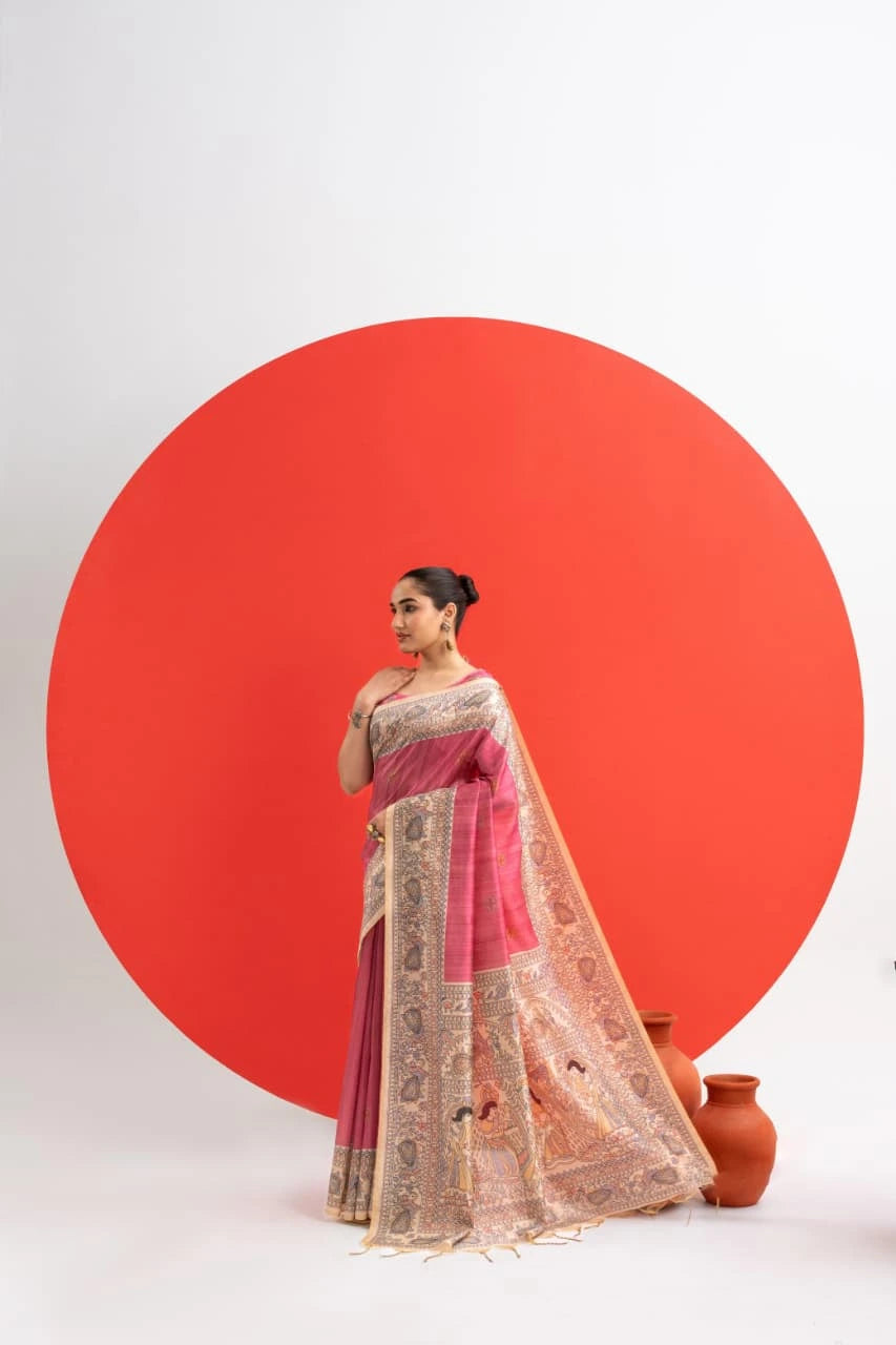 Woman in a pink saree with intricate patterns standing against a white background with a large red circle.