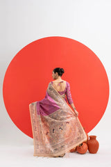 Woman in a traditional saree standing in front of a large red circle on a white background