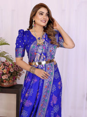 Woman in a blue saree with floral patterns against a white background