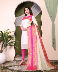 Woman wearing a traditional outfit with white and pink design, standing indoors.