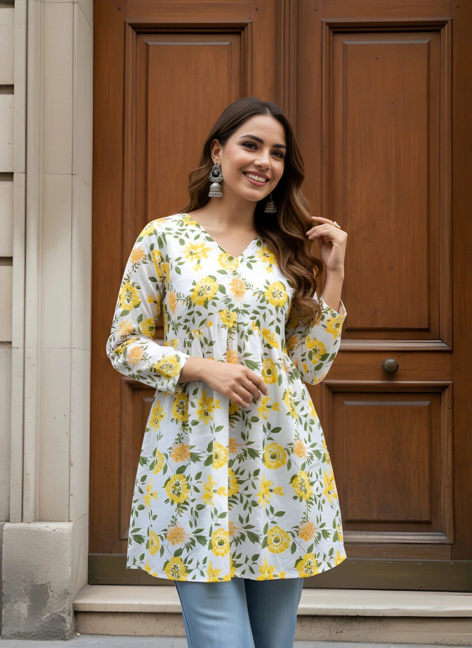Woman wearing a floral dress standing in front of a wooden door.