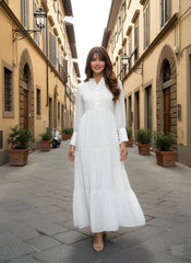 Woman in a white dress walking down a European street.