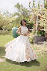 Eye-catching golden circular foil patterns add a sophisticated and festive touch to the elegant white skirt.