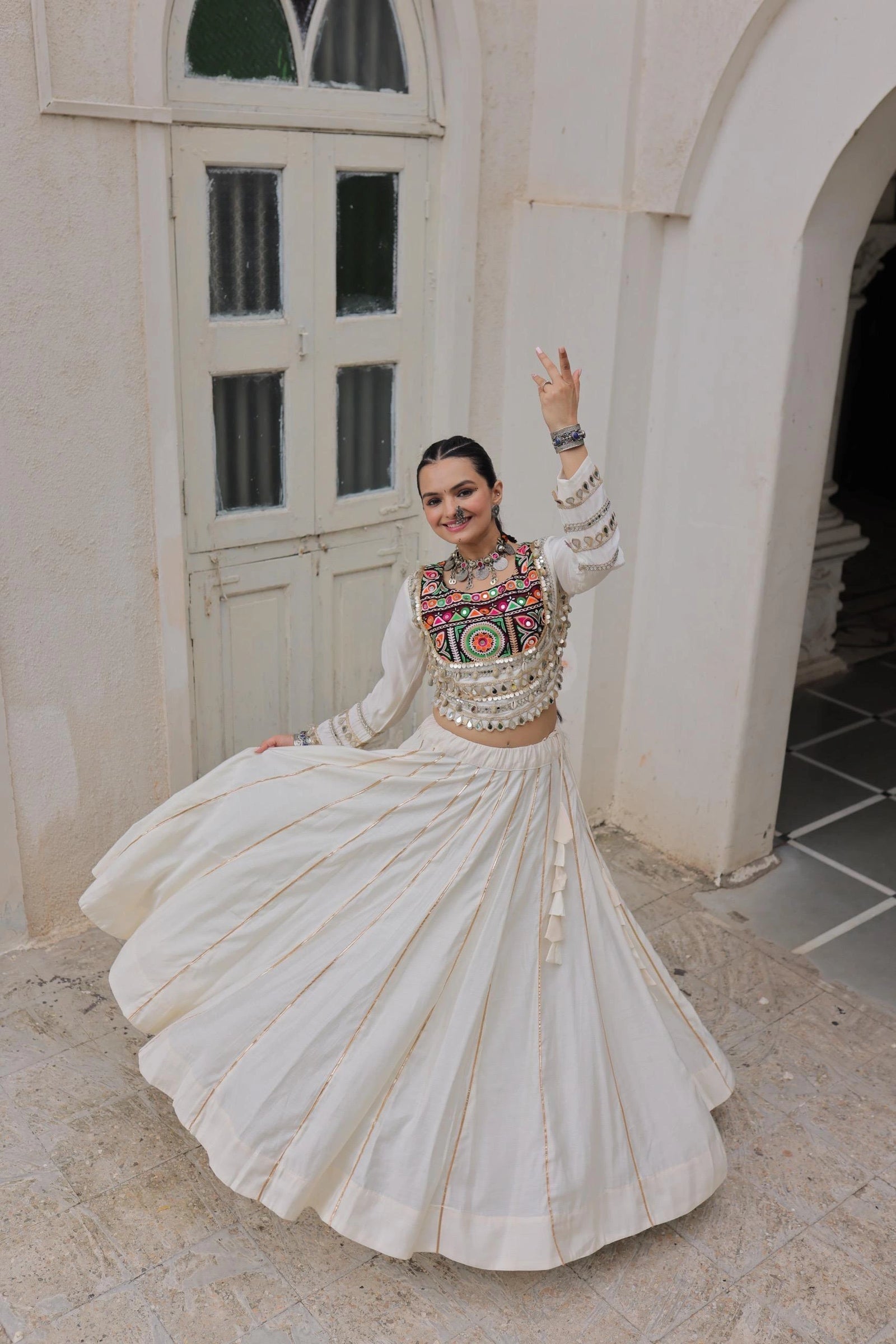 Woman in traditional outfit with intricate patterns in an outdoor setting