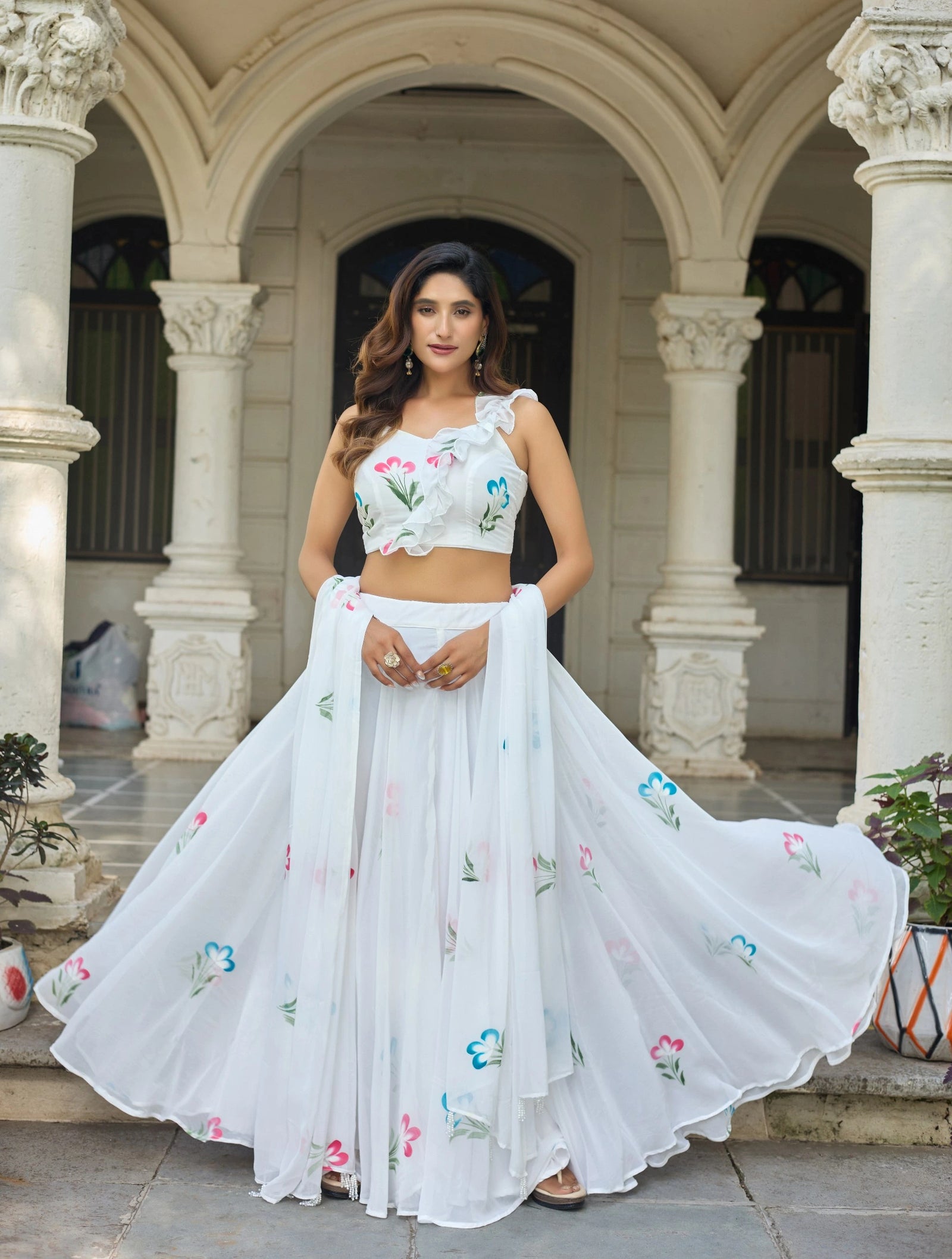 Woman in a white embroidered outfit standing in an architectural setting