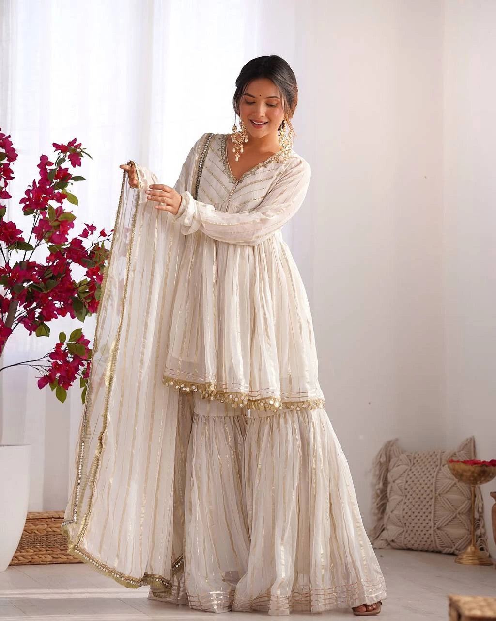 Woman in a traditional outfit with a white background and decorative elements.
