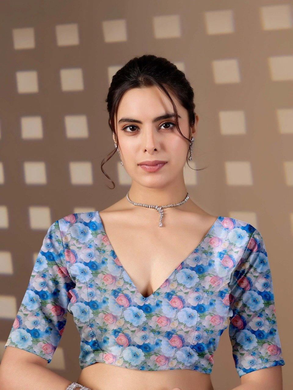 Woman wearing a floral blouse with a checkered wall background