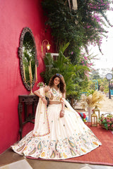 Woman in a traditional outfit standing in front of a red wall with decorative elements.