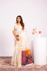 Woman wearing a white saree with a colorful design, standing against a white background.