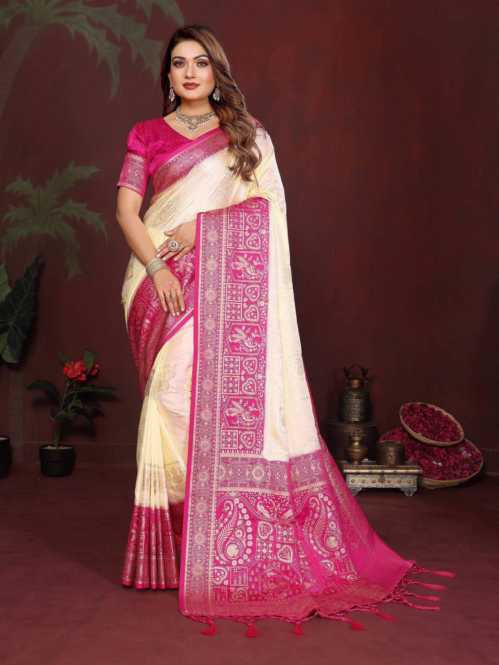 Woman wearing a pink and white saree with a dark background