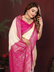 Woman wearing a pink saree with a white border against a dark background