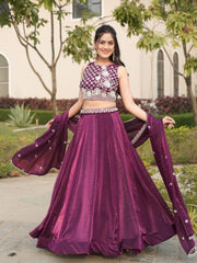 Woman in a purple traditional outfit with a matching dupatta outdoors.