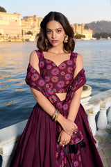 Woman in a floral dress standing by a waterfront with historical architecture in the background