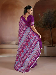 Woman wearing a purple saree with a pattern in an indoor setting