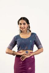 Woman wearing a traditional outfit with a blue blouse and purple skirt on a white background