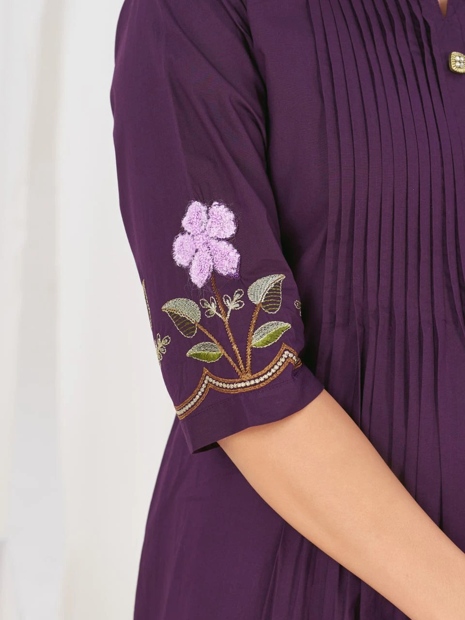 Purple dress with floral embroidery on a white background