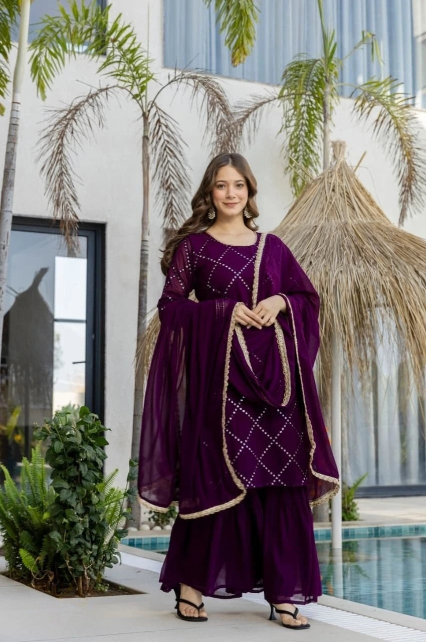 Woman in a purple traditional outfit standing by a pool with palm trees in the background