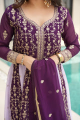 Purple embroidered traditional outfit with gold details on a blurred background
