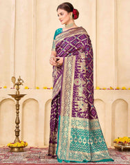 Woman wearing a purple and green saree with a decorative background