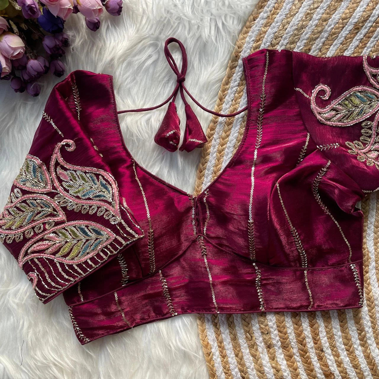Maroon blouse with intricate embroidery on a textured surface
