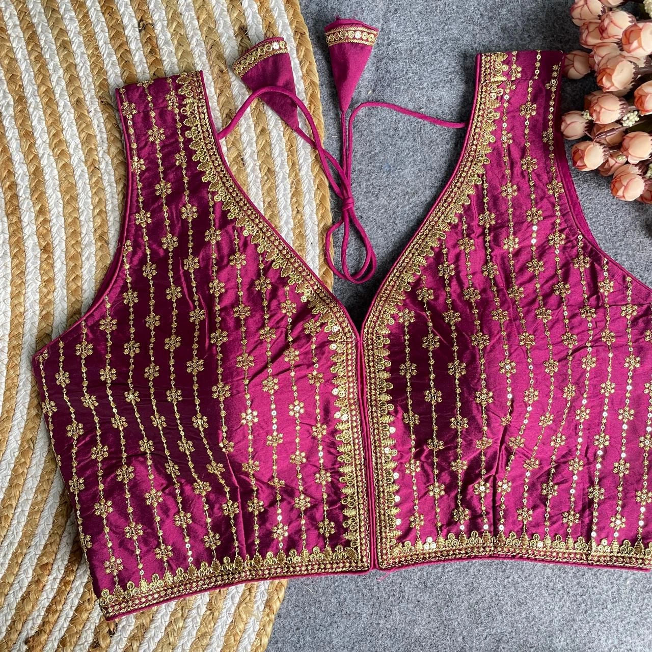 Pink embroidered blouse with gold details on a striped fabric background