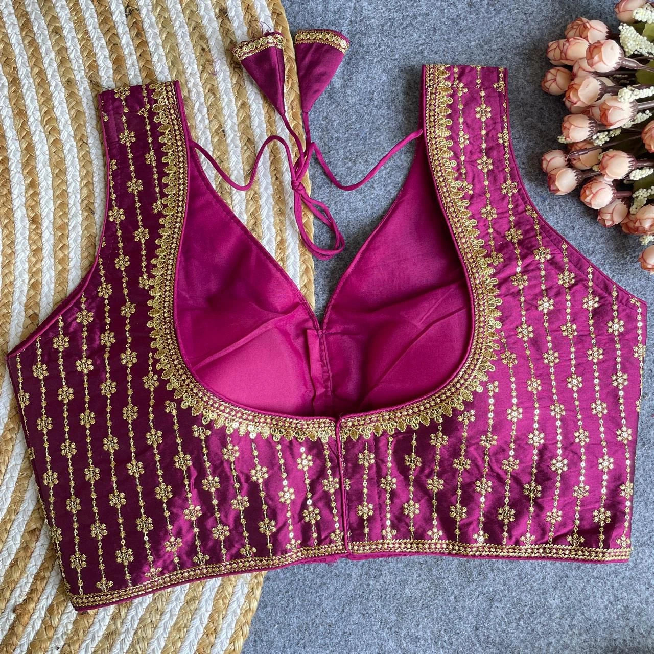 Purple embroidered blouse with gold details on a striped fabric background