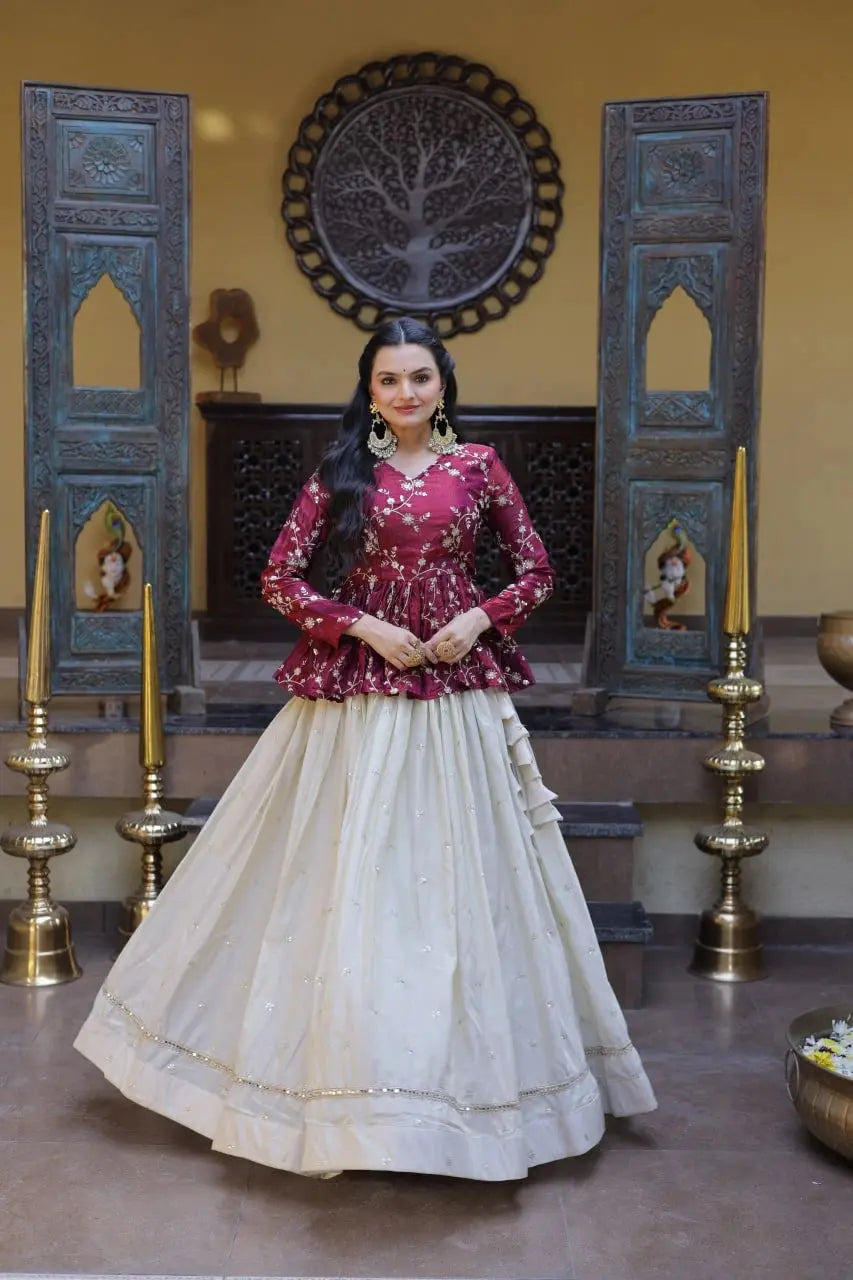Woman in a red and white traditional outfit standing in a decorated room with wooden doors and wall art.