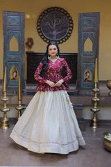 Woman in a red and white traditional outfit standing in a decorated room with wooden doors and wall art.