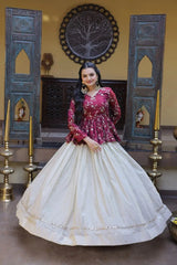 Woman in a red and white traditional outfit standing in a decorated room with blue wooden panels and gold candle holders.