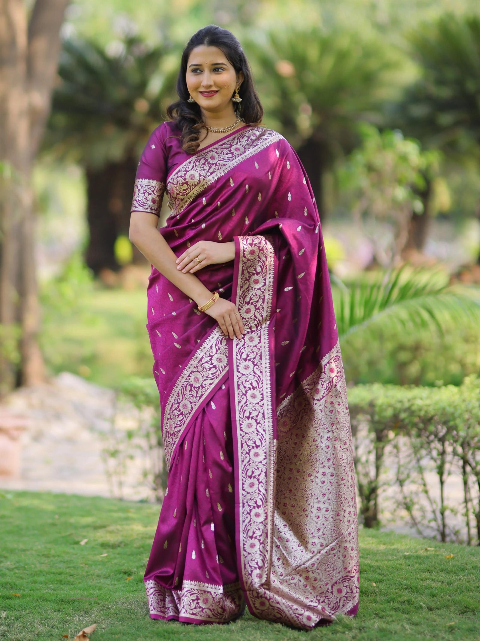 Woman wearing a purple saree with a garden background