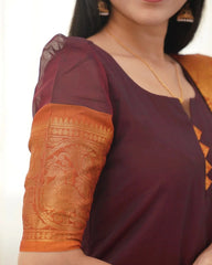 Close-up of a maroon and orange traditional outfit with intricate patterns.