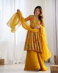 Woman wearing a yellow floral outfit with a matching dupatta in a bright room.