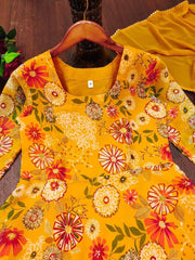 Yellow floral dress on a wooden hanger with a dark background
