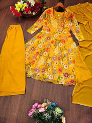 Yellow floral top with matching skirt on a wooden surface with flowers.