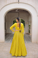 Woman in a yellow traditional outfit standing in an archway.