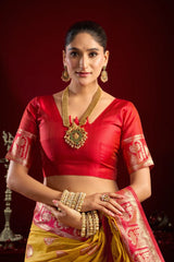 Woman in traditional red and yellow saree with jewelry against a dark background