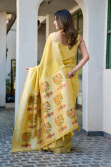Woman wearing a yellow saree with floral patterns in an outdoor setting