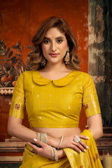 Woman wearing a yellow traditional outfit with intricate designs.