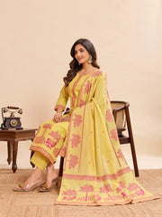 Woman wearing a yellow and pink embroidered traditional outfit in a room setting.