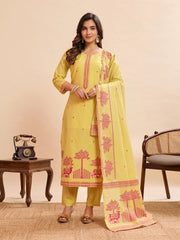 Woman wearing a yellow traditional outfit with pink patterns on a beige background