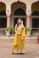 Woman in a yellow traditional outfit standing in front of a colorful architectural background