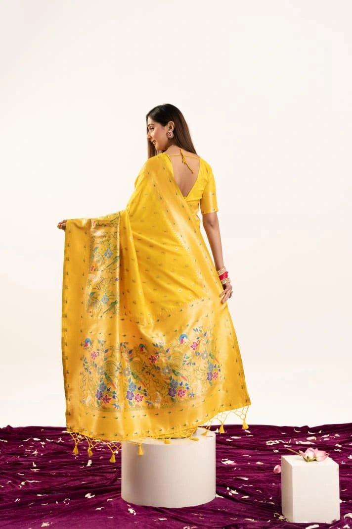Woman in a yellow saree with floral patterns on a white background